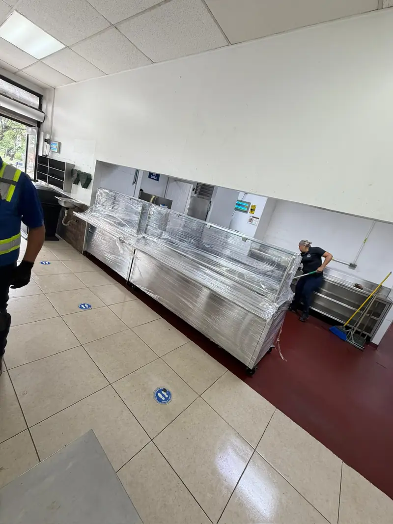 Línea de servicio con guardapolvo de cristal entregada en cocina industrial